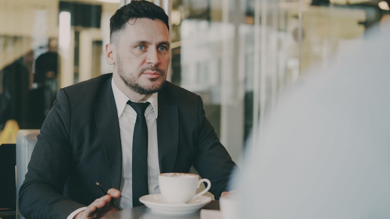 5. 리스크 요인 - Man in suit talking across table with co