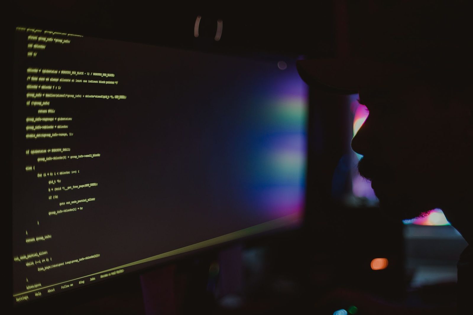 software developer reviewing code on multiple monitors...