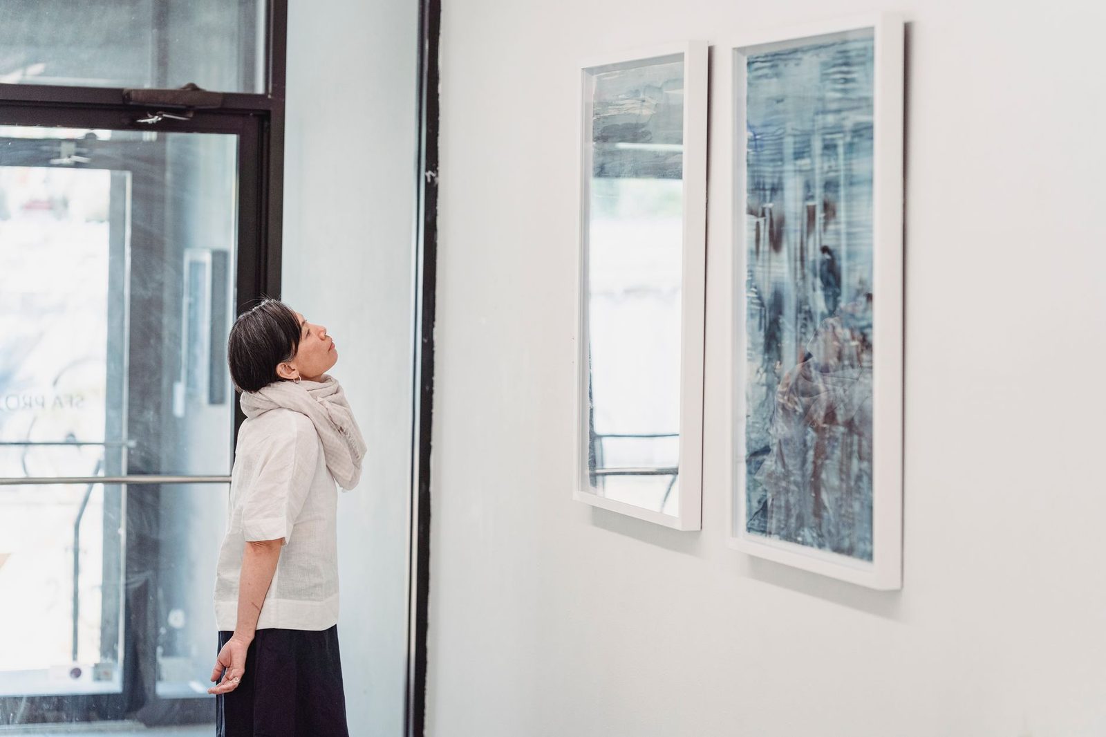 minimalist contemporary art gallery lone visitor looking...
