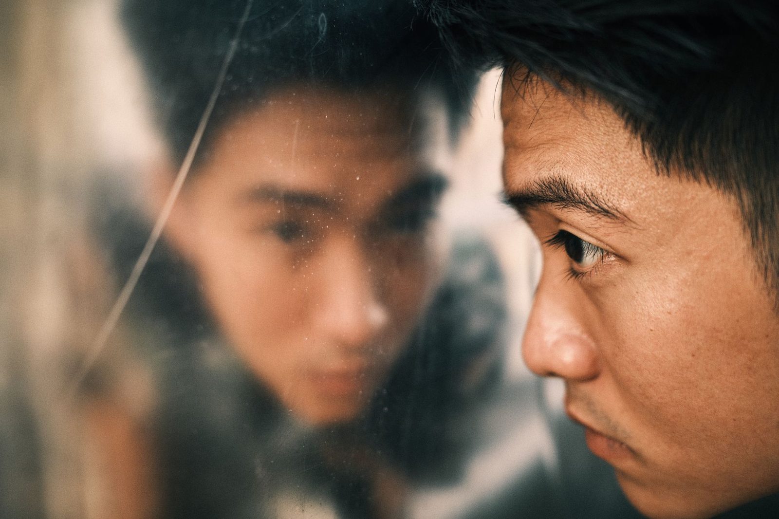 close-up person looking into mirror reflection...